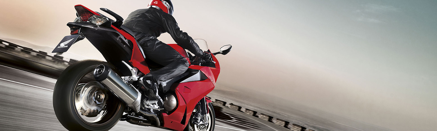 Man riding a black and red Honda® motorcycle on a race track