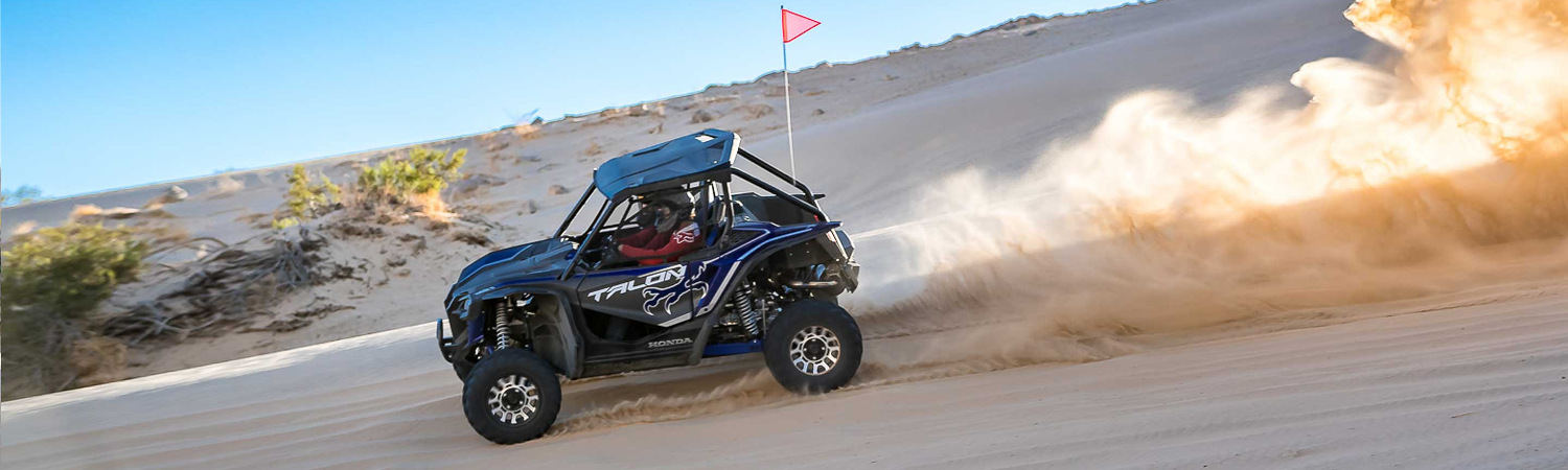 Two people riding a Honda® Talon UTV in the desert